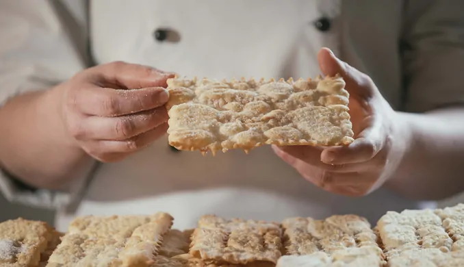 Le mani del pasticcere spezzano una chiacchiera di Carnevale