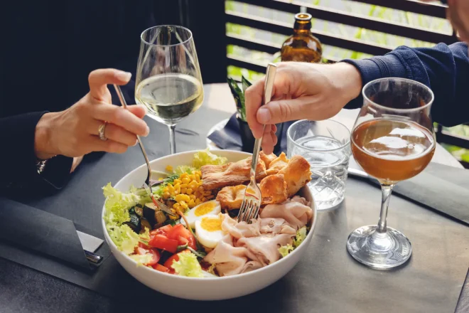 Insalatona con tacchino, uovo, mais e pomodorini servita al tavolo